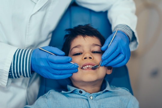 chłopiec na fotelu dentystycznym